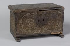 Small, ornately carved chest with metal hardware.