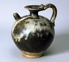 A globular stoneware ewer with a narrow foot and narrow trumpeted neck with direct rim, short straight spout placed high upon the shoulder. The ewer has a coiled handle with articulation extending from the mouth to the shoulder, and is covered in a dark brown glaze stopping high above the foot, with white glaze applied on top of the dark brown on the shoulder, creating a mottled effect with bluish suffusions. 