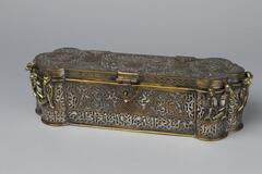 This metal scribe box has multiple containers inside to hold ink and other needs of the scribe. It is ornately decorated on the exterior and interior.