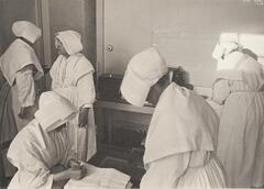 A group of nuns folding linens.