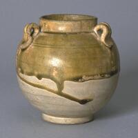 A stoneware globular jar on a foot ring with a wide mouth, a short, straight neck with direct rim, four coil looped lugs connecting neck to shoulder, a bow string incised line around shoulder, and the top half covered in a straw-colored glaze. 