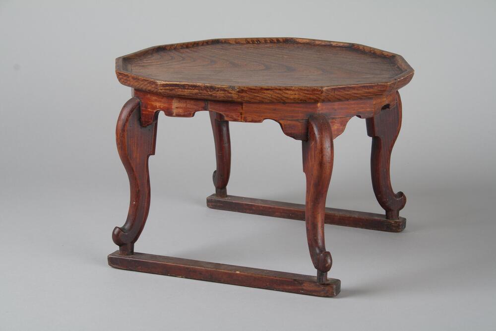 Wooden table with a dodecagon table top with a geometric band underneath. Legs are s-shaped and tapered at the foot.<br />
<br />
This tiger-legged tray-table has its name derived from the shape of its out-curved legs which resemble those of tigers. The brim is carved out from the table top, instead of joining the separatelymade brim. Four pieces of aprons are inserted into the table top then fixed with bamboo pegs. The stretchers have marks of square-shaped pegs from the legs, but they are fixed by steel nails.
<p>[Korean Collection, University of Michigan Museum of Art (2017) p. 259]</p>
<br />
&nbsp;