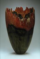 Large, turned wood vessel. Fire has been used to color and texture the surface. Bark has been left on to provide texture. The mouth of the vessel is jagged.<br />
large burnt wood vessel with bark marking the top irregular edge