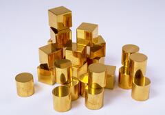 Twelve identical cubes and twelve identical cylinders of gold-plated steel. They are rearrangeable.