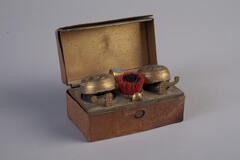 A travel box with two inkwells and a brush. The inkwells have metal lids and glass bases.