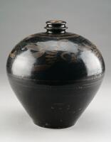 A bottle with wide shoulders tapering to a narrow foot and a narrow, short, double ring neck and mouth.  It is covered in a dark brown-black glaze, with freely painted, russet colored floral decoration around the shoulder.  