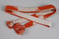 Orange, silver and gold woven pattern with orange and silver fringe on both ends.