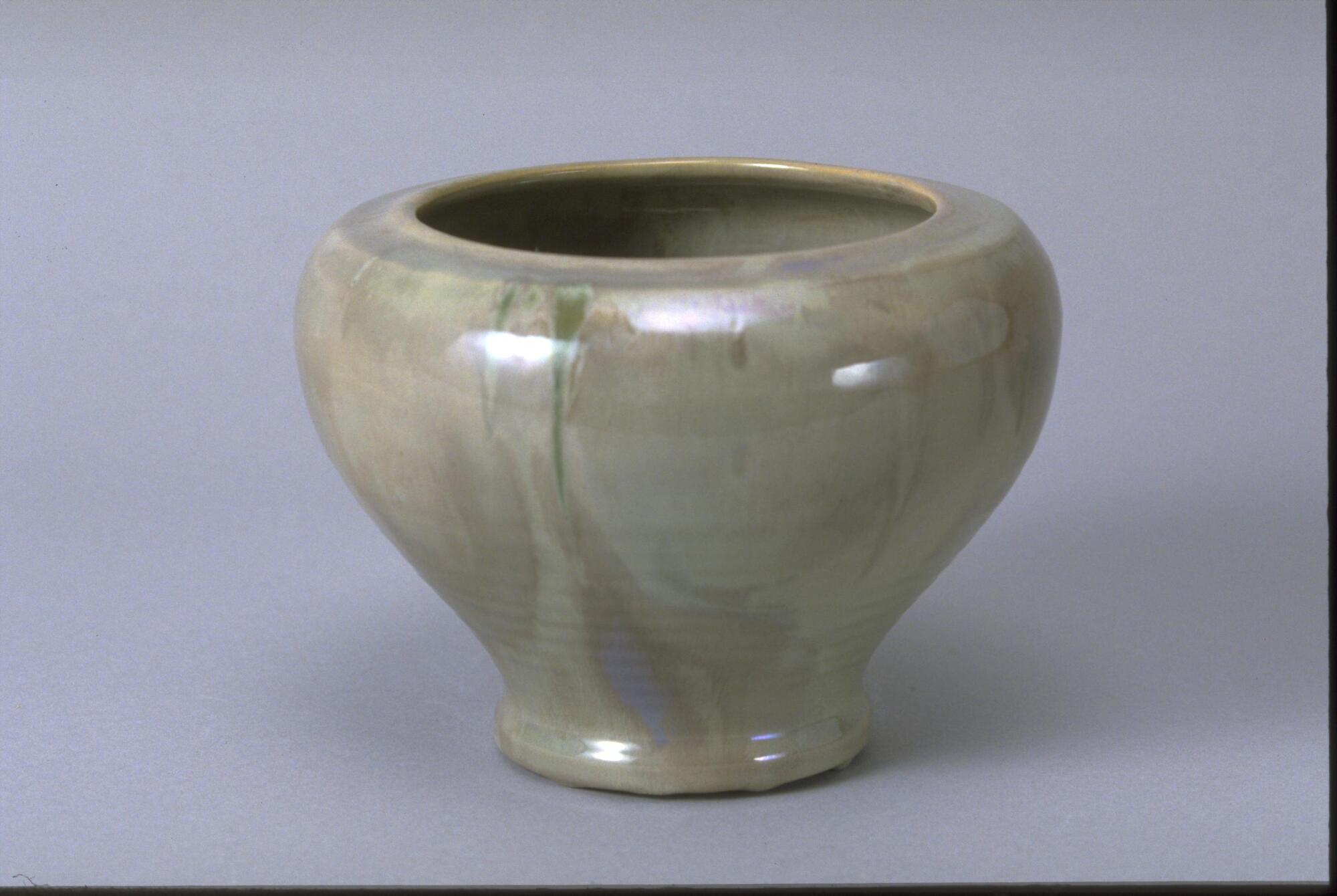 Ceramic vessel with rounded shoulder, large mouth and no neck or lip covered with heather green-gray glaze. The rings of the thrown clay can be seen beneath the glaze.