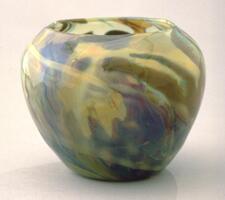 Multiple layser of translucent glass in brown, green, and tan creates a rich texture of glass that resembles tortoise shell. The vessel has a very simple profile.