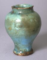 This vase is in the baluster shape and has a fine turquoise blue crackled glaze. It has been broken in many pieces and restored. The composition of the body is in line with typical pottery techniques found in major centers of the Iranian Islamic world which utilized a frit body covered with glaze. 