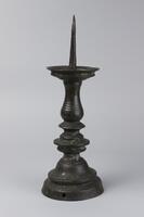 Tall candlestick with pointed top and rounded bottom.