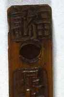 A bamboo stick with carved characters running vertically along the stick.