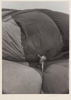 A child playing on top of a deflated circus tent.