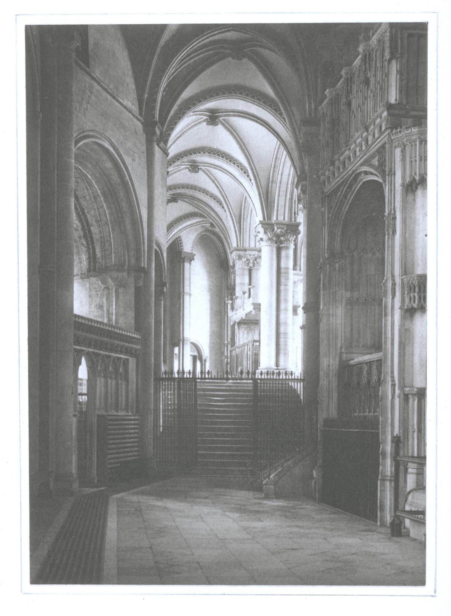 Photograph of a view looking into the choir of Canterbury Cathedral. Of central focus are the pilgrim steps leading into the choir. This image depicts the combined Romanesque and Gothic architecture of the cathedral.