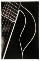 This black and white photograph shows a partial view of a guitar against a solid black background. It is a cropped, close-up image showing a portion of the fingerboard and upper bout.