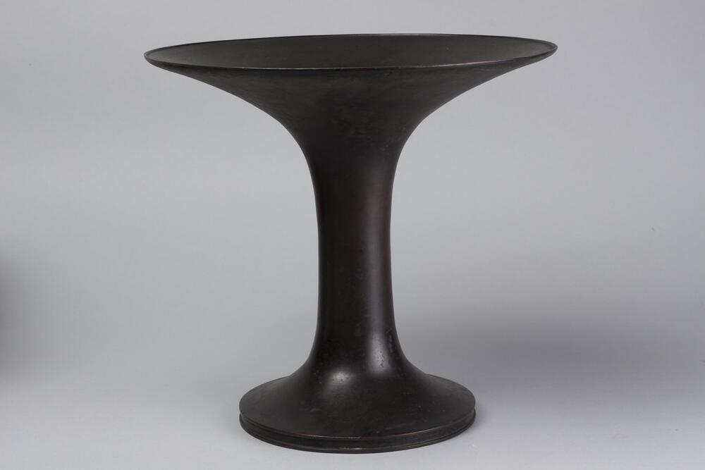 Bronze vase with raised plate top.