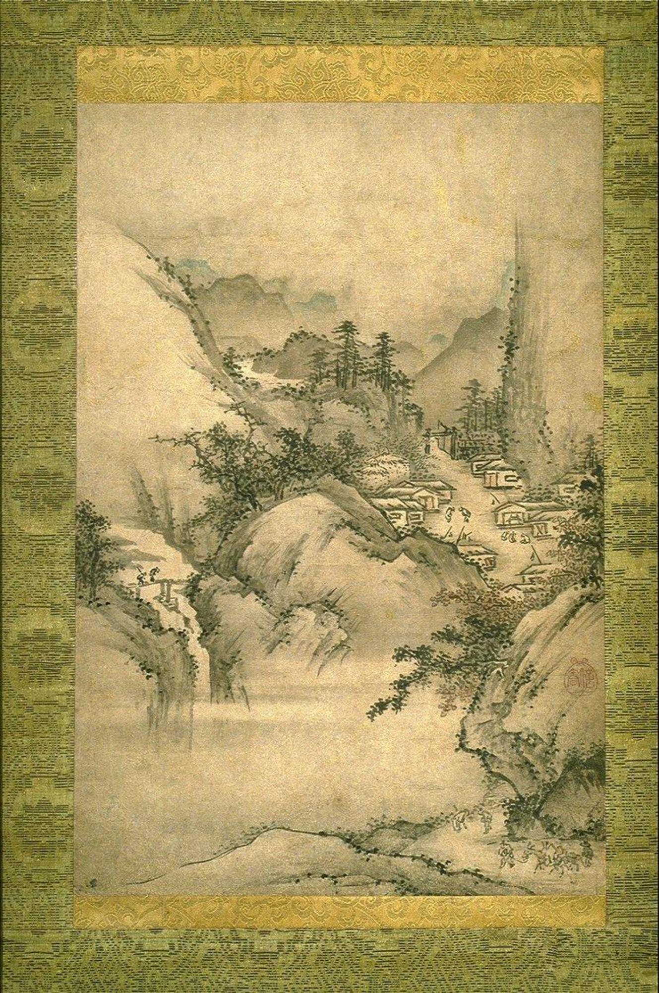 This is a vertical format painting surrounded by green and gold fabric. It is painted in tones of black with some areas of pink and blue color. It depicts a landscape scene with a cluster of small houses nestled in a craggy mountainous area. There is a river that runs through the landscape with two figures crossing a small footbridge. Other figures are shown in the open area of the village. The trees and vegetation are painted with short abbreviated brushstriokes.