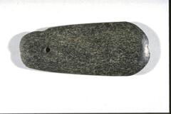 Stone part of a chisel made of black pitted stone. It is oval in shape with curved edges and one end length is thicker than the other.