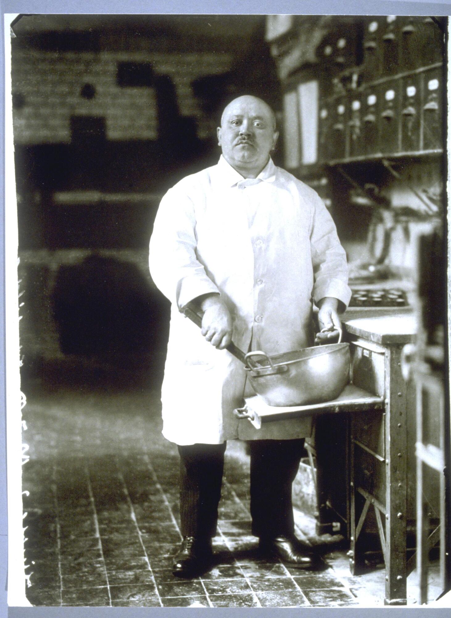 A formal portrait of a pastry chef in his commercial kitchen. 