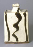 This rectangular clay bottle has a speckled white glaze that seems to highlight the texture of the stoneware underneath.  Three dripped, irregular lines of black glaze create a design on the top, spout, and widest two faces of the bottle.