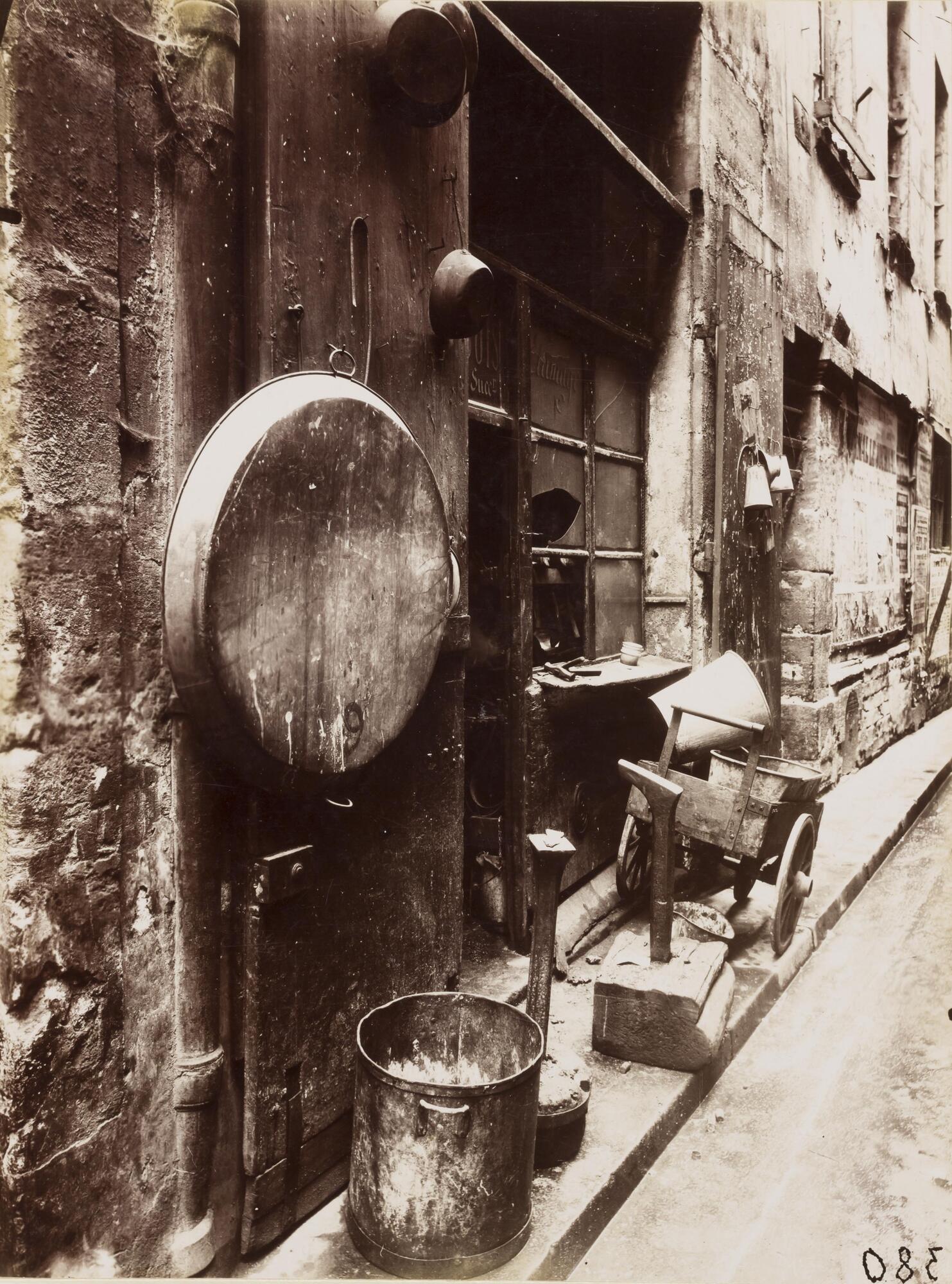 View of the exterior of a tinsmith's shop in a Parisian passageway.