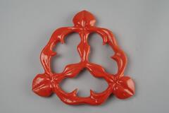 Orange in color and floral in shape. Is attached to the larger base pieces when installed.