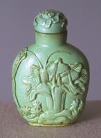 A turquoise? snuff bottle. Carved in high relief on the surface of the snuff bottle is a cricket sitting on top of a large plant with smaller plants surrounding it. On top of the snuff bottle is a large mouthpiece with a stopper also carved with plants.