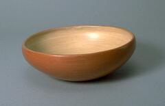 Shallow bowl with wide opening. Brown-red slip exterior with a light brown interior.