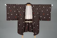 <p>Dark brown silk haori with interwoven geometric hexagonal patterns and dyed white and red dots with an off-white inner lining with interwoven wavy lines.</p>
