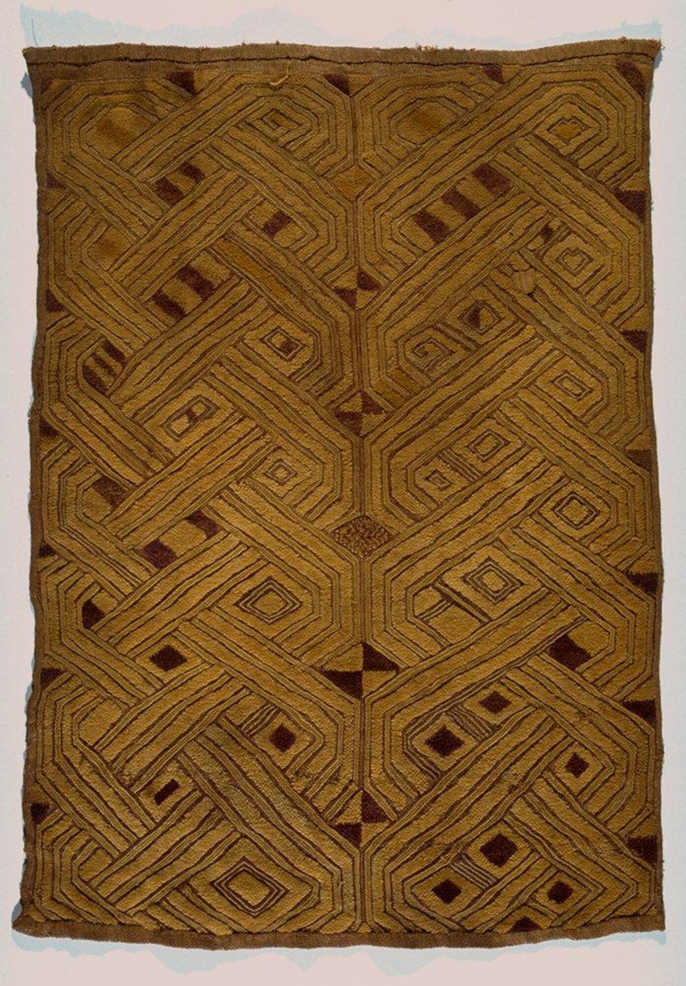 Rectangular panel with hemmed edges. There are two rows of patterns running down the panel consisting of multiple interlocking lines.
