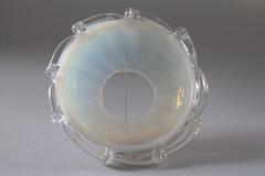 A clouded glass half-orb with a hole in the center, and clear glass scrolling accents along the outer edges.