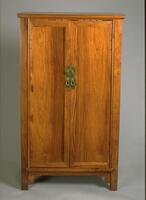 A two door wooden floor cabinet with brass handles.