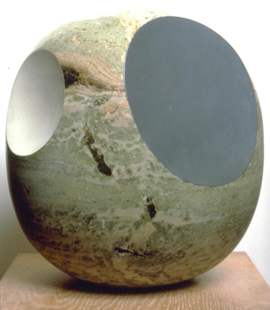 Oval-shaped piece of veined, green Swedish marble standing on one of its narrow ends. Three holes of different sizes penetrate into the object's center. The holes are painted in a semi-gloss black and matte white.