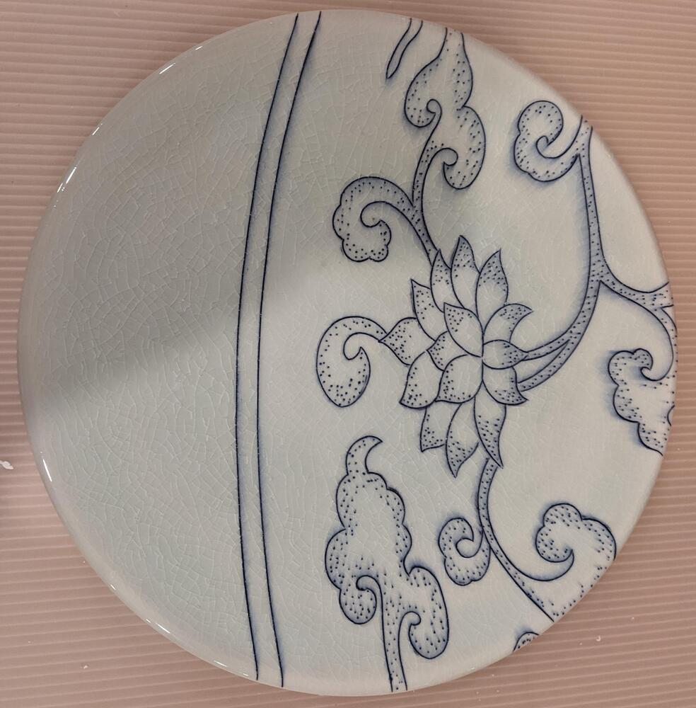 Border plate with two vertical blue lines across the center of the plate. To the right of the lines are blue flowers and branches.&nbsp;