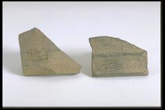 A trapezoidal-shaped earthenware shard, unglazed, with ridged lines and impressed stamped design. 