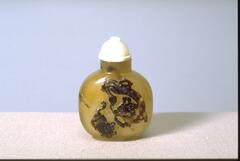 An agate snuff bottle with depictions of dragons.