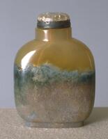 A square shaped moss agate snuff bottle with rounded edges. on the top of the snuff bottle is a quartz stopper set in a silver collar.