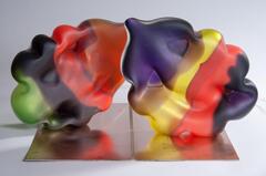 A balloon-like shaped piece that is completely enclosed. There are bands of color that blend into one another in purple, red and orange. The otherwise open interior meets at two triangular points inside in the purple colored sections.