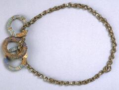 Belt with a band made of metal chain and three beaded rings attached to the center front. One of the rings has been reparied with packing tape. 