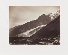 Photograph of a glacier in the Alps near Savoie, viewed from a village at the base of the mountains.