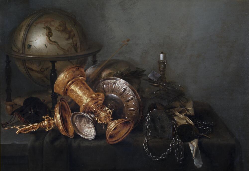 This remarkable still life depicts a table crowded with, among other things, a gilded covered goblet, a wide saucer-shaped silver tazza, a celestial globe painted with images of the constellations, a skull wearing a laurel wreath, and an extinguished candle, all rendered in exquisite detail with careful attention paid to the effects of light and texture. While the arrangement of objects may appear casual, the composition is artfully balanced along two diagonal axes centered on the two cups that lie crossed on the table. The repetition of ovoid shapes throughout the painting and the monochrome tonality with its restricted range of hues and values, a hallmark of Heda's style, assures the seamless integration of the sundry objects into a unified whole.<br />