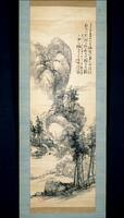 A satin hanging scroll painted with ink, this painting focuses on a cliff face. At the foot of the cliff is a roofed building surrounded by trees and a path. The trees climb up the cliff up to the upper fourth of the painting. To the left of the building is a body of water. A small waterfall feeds into it from the lower regions of the cliff. On the right is a distant background scene. The upper right contains four inscriptions two of which, furthest to the right, are written higher than the following two. On the left of the inscription are two red seals on top of each other obscured by the inscription. There is another red seal on the bottom left corner as well.