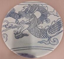 A plate from the border of the piece. A dragon&#39;s head and portion of its body is bordered by horizontal lines.&nbsp;