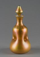This orange/yellow iridescent decanter with a triangular-shapped stopper is pinched in the middle, dividing the vessel into several separate channels.