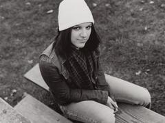Overhead view of a teenage girl looking up at the camera. She is wearing jeans and a white hat.