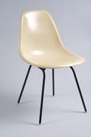 Cream-colored side chair consisting of a single plastic "shell" mounted on a black, four-legged metal base (an "H" base).