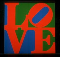 The word &ldquo;love&rdquo; printed in capital letters in red on a blue and green background with a black border or frame