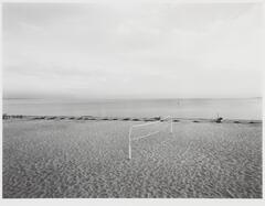 Empty beach with volleyball net set up.