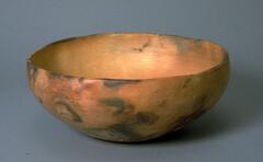 Brown bowl with black smudgy markings throughout.
