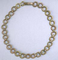 Belt in the form of brass rings linked together by smaller loops of metal. 